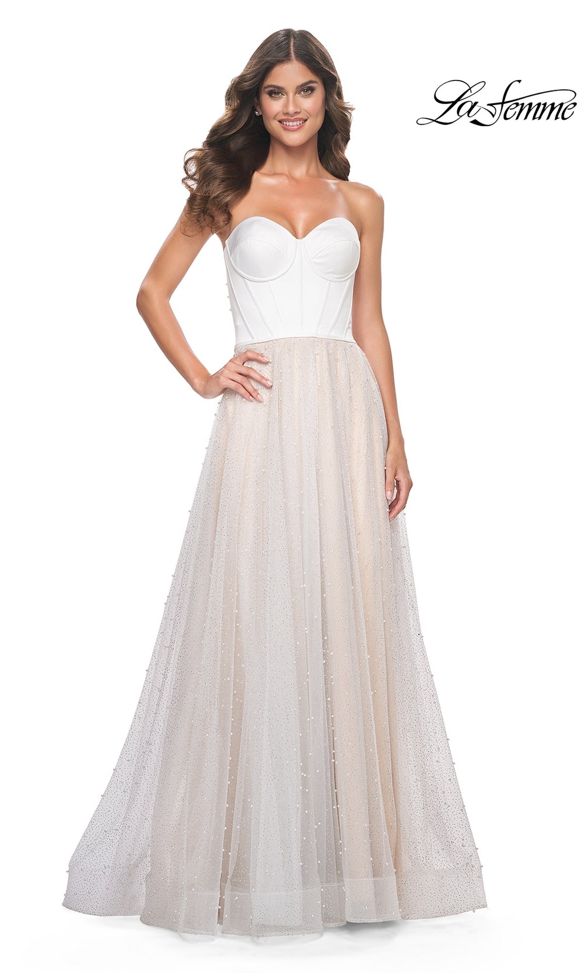 A woman models the La Femme Strapless Long White Prom Dress 32149, featuring a sheer, sparkly tulle skirt, against a plain white background. The